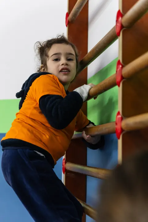 A girl climbing the wall bars