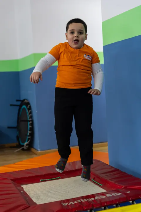 A boy bouncing on a trampoline