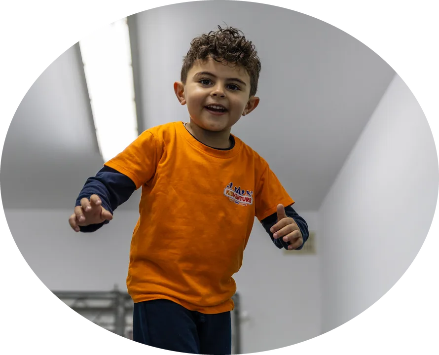 A smiling boy balancing on a beam